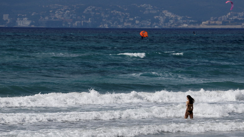 Eine Frau am Strand von Arenal: Viele Spanier dürfen nicht auf Mallorca reisen, Deutsche hingegen schon.