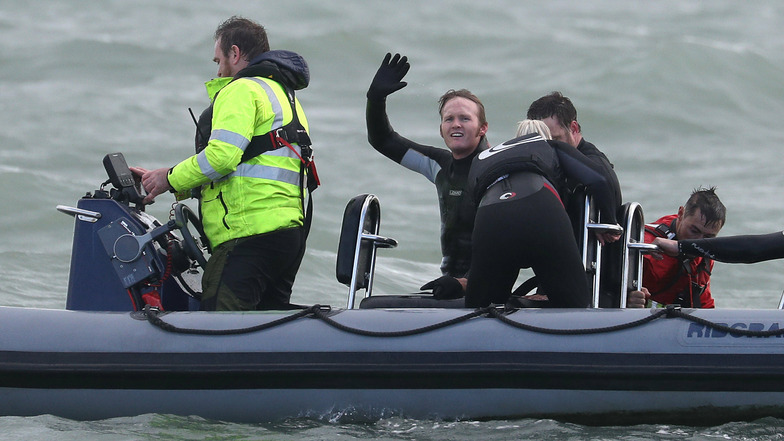 John Bream, ehemaliger Fallschirmspringer aus Großbritannien, winkt aus einem Boot, das ihn nach seinem Sprung aus etwa 40 Metern Höhe ins Meer geborgen hat.