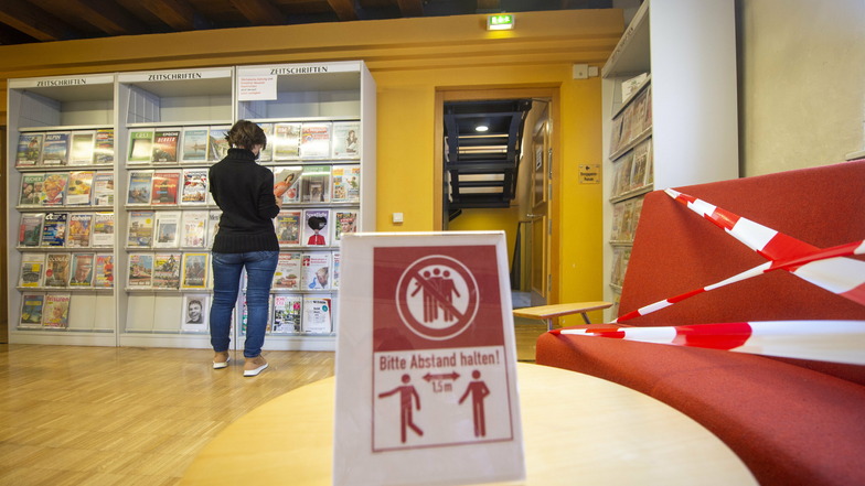 Eine Mitarbeiterin steht in der Stadtbibliothek in Pirna vor einem Regal. Aufgrund der aktuellen Einschränkungen ist die Einrichtung noch bis zum 7. Februar geschlossen,