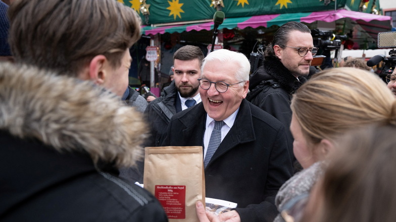 Frank-Walter Steinmeier bekommt auf dem Weihnachtsmarkt von Schülern Kaffee aus Nepal und einen Kalender geschenkt.