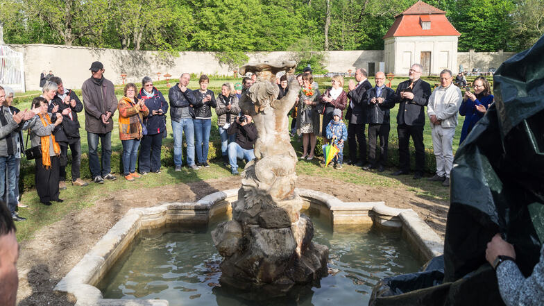 Der erste der vier kleineren Brunnen ist fertig und wird vor etlichen Besuchern enthüllt.
