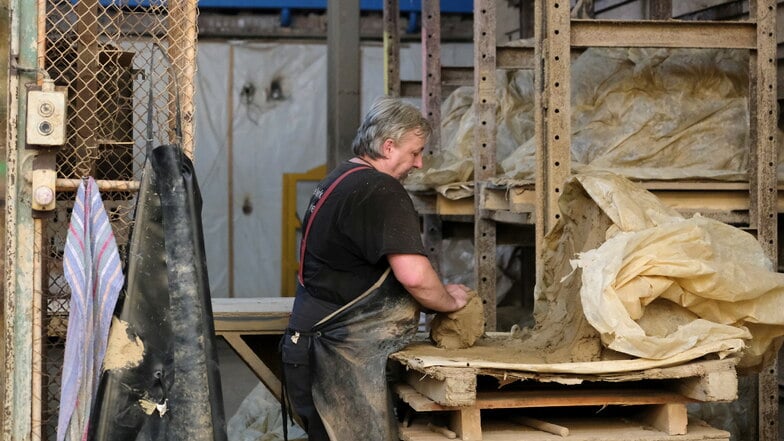 Andre Schiebelbein gehört seit zwei Jahrzehnten zum Team des Ziegelwerkes. Er nutzt eine Holzform, um aus der Lehmmasse die Steine zu formen - in Handarbeit.