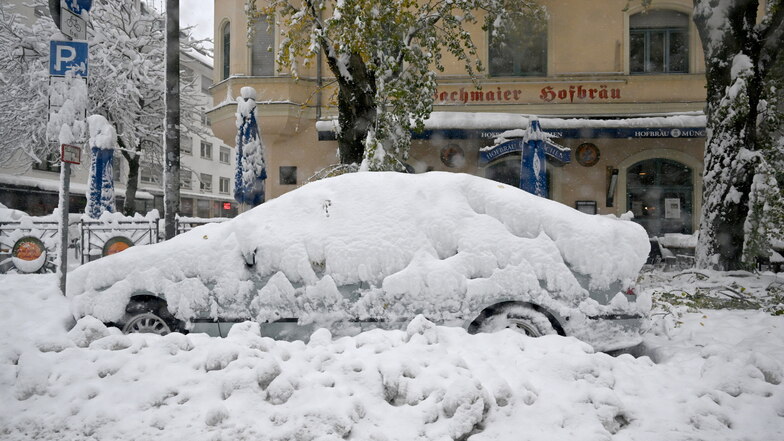 Schneemassen liegen auf einem Auto in München. Schnee und Eis haben im Süden Bayerns auf den Straßen und bei der Bahn für Chaos gesorgt.