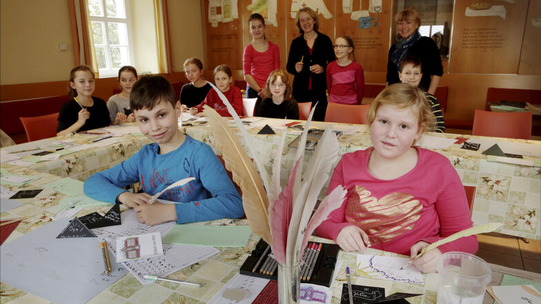 Kerstin Göder (hinten Mitte) vermittelte zehn Mädchen und Jungen den Spaß an alten Schriften und Gerätschaften, die aus ausprobiert werden konnte.