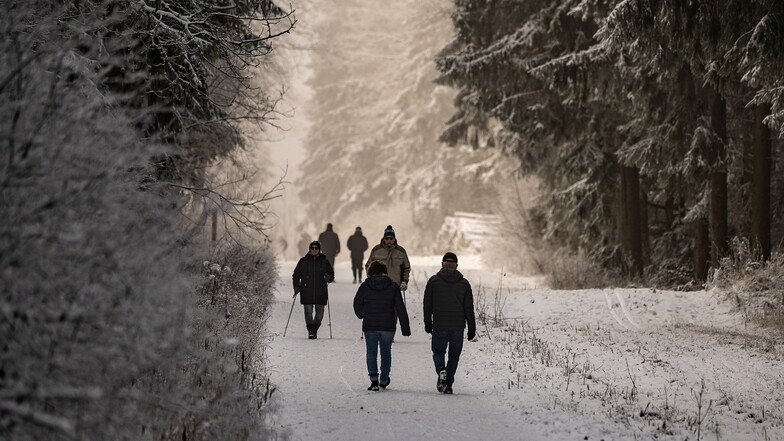 Hessen, Hoher Meißner: Fußgänger gehen durch den verschneiten Naturpark Hoher Meißner.