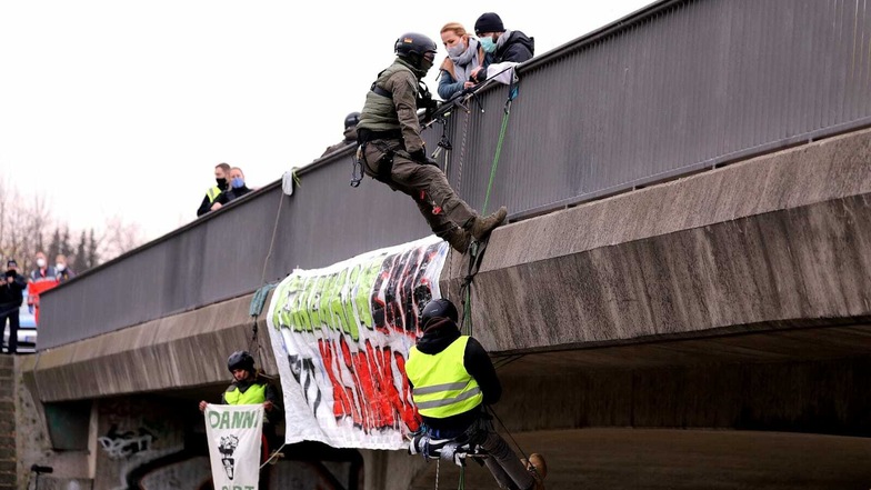 Spezialisten der Polizei holen die abgeseilten Klimaschützer von der Brücke.