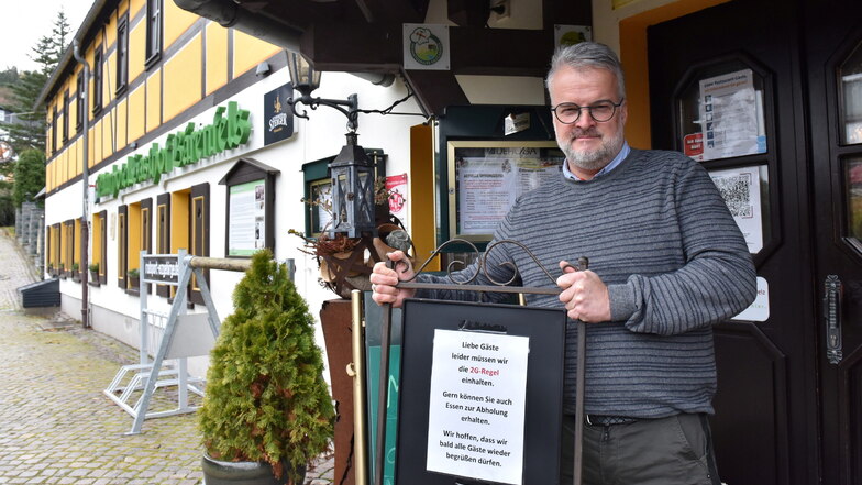 Jan Kempe, Mitglied im Wirtestammtisch Osterzgebirge, stellt am Gasthof Bärenfels Ende November das Schild mit den geltenden 2G-Regeln auf.