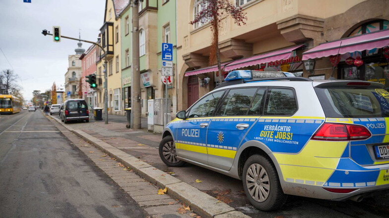 Ein Polizeiauto steht beim Einsatz gegen die Reichsbürger-Szene in Dresden-Laubegast vor einer Filiale der "Gemeinwohlkasse".