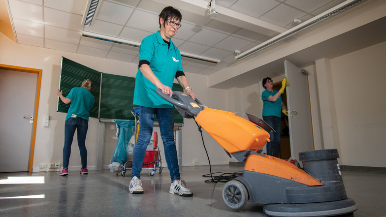 Gabriele Dähne von der Firma H&P Gebäudereinigung reinigt den Fußboden eines Klassenzimmers in der Grundschule Am Holländer mit einer Scheuermaschine.