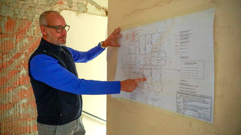 Thomas Illert, Geschäftsführer des DRK Aue-Schwarzenberg, zeigt die Pläne für die beiden Obergeschosse, in denen acht Familiensuiten mit insgesamt 32 Betten entstehen sollen.