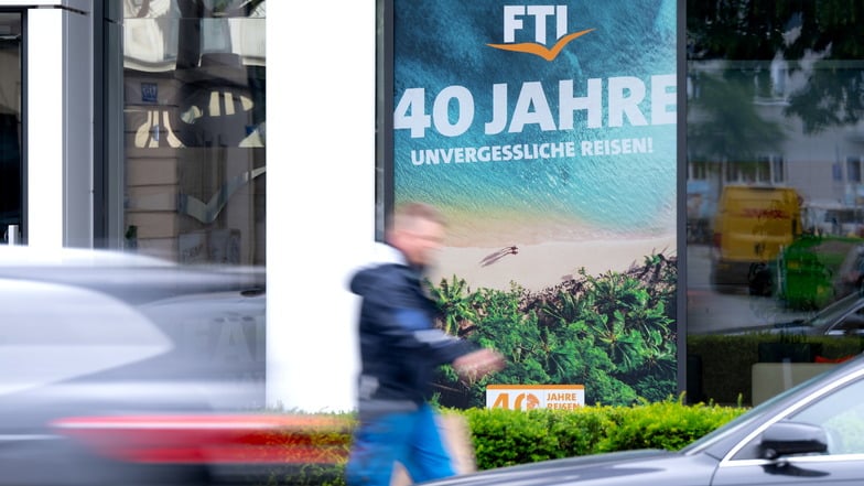 Ein Plakat des Reiseveranstalter FTI hängt an der Firmenzentrale in München. FTI ist pleite und wird jetzt abgewickelt.