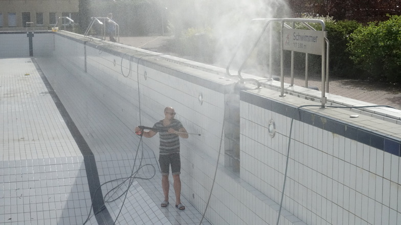 Badleiter Toni Bunzel reinigt das abgelassene Becken im Döbelner Freibades. Die Eröffnung ist für Ende Mai geplant - wenn das Wetter passt.