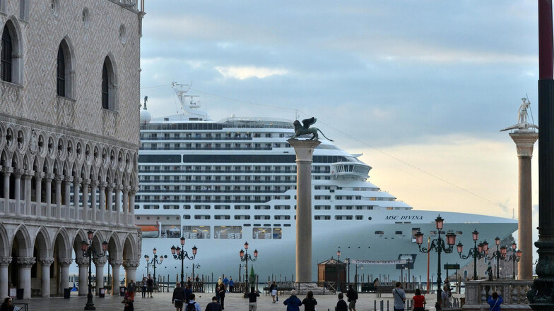 Ein riesiges Kreuzfahrtschiff legt in Venedig an und bringt massenhaft Tagestouristen in die Stadt.