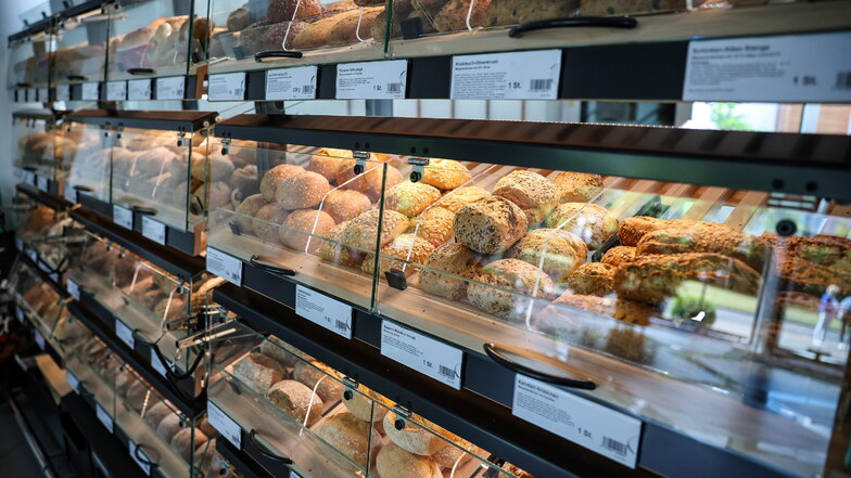 Brot und Brötchen liegen in einem Regal einer Großbäckerei (Symbolbild). Mit dem Stangengrüner Mühlenbäcker und dem Lila Bäcker sind gleich zwei große ostdeutsche Backketten ins Trudeln geraten.
