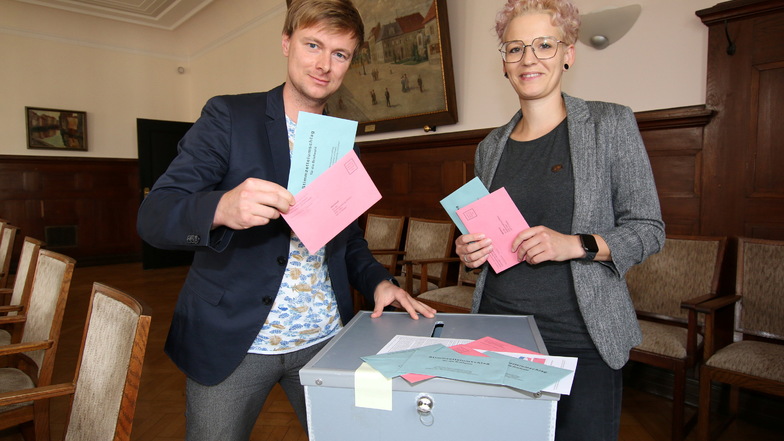 Wahlleiterin Natali Möckel und ihr Stellvertreter Andy Scharf stehen an einer der Urnen, in denen die Wahlbriefe bis zur Auszählung aufbewahrt werden. Die können verschlossen und versiegelt werden.