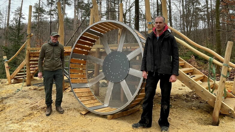 Revierförster Matthias Protze (li.) und Zimmerer Bernhard Witte mit dem 2-Meter-Hamsterrad. Noch befindet sich das Mini-Sägewerk im Aufbau.