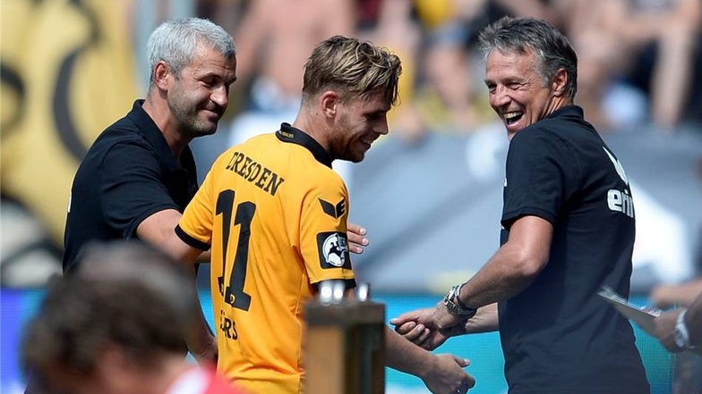 Justin Eilers lacht bei seiner Auswechslung mit Trainer Uwe Neuhaus (r.) und Co-Trainer Peter Nemeth.