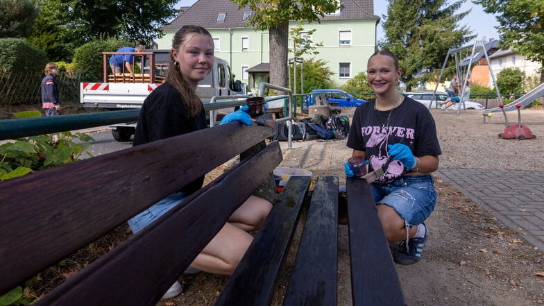 Viktoria Förster (links) und Ida Ring (rechts) streichen eine Bank auf dem Spielplatz Am Zänker.