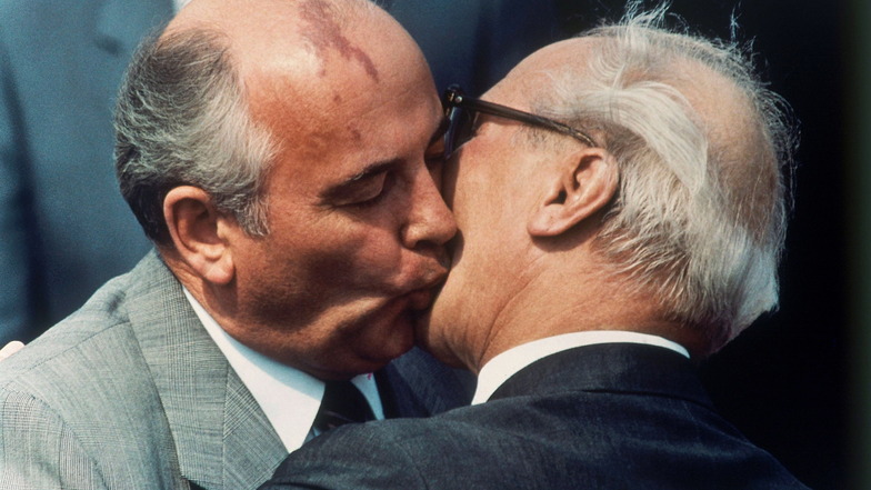 Michail Gorbatschow (l.) und DDR-Staatschef Erich Honecker tauschen auf dem Ostberliner Flughafen Schönefeld einen Kuss aus.