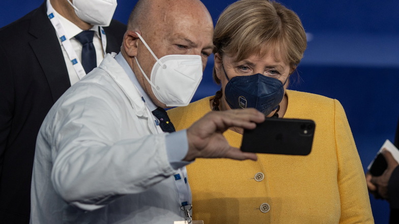 Ein Mitarbeiter des italienischen Gesundheitswesens macht beim g20-Gipfel in Rom ein Selfie mit Angela Merkel.