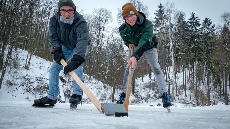 Dominik (links) und Frederik aus Wendishain spielen auf dem Angelteich an der Muldenwiese in Westewitz Eishockey.