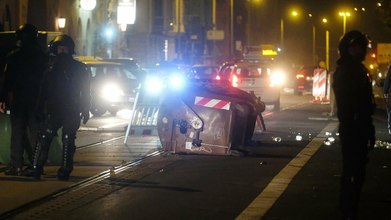 Polizisten stehen auf einer Straße in Leipzig-Connewitz, auf der Gegenstände als Barrikade liegen. Am Rande einer Demonstration kam es dort am Freitagabend zu Ausschreitungen.