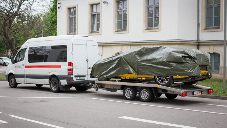Der goldene Porsche darf wegen seiner spiegelnden Folierung, die in Deutschland verboten ist, nur abgedeckt transportiert werden.