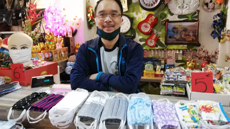 Nhat Nguyen ist Inhaber eines Geschäftes für Asia-Mode in Görlitz. Er verkauft jetzt auch Mund-Nase-Abdeckungen. Nur fürs Foto hat er seine eigene Maske kurz gelüftet.