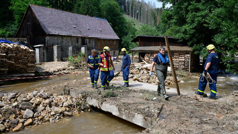 Einsatzkräfte des THW beseitigen Mitte Juli am Krippenbach in Krippen Geröll und begutachten die Schäden.