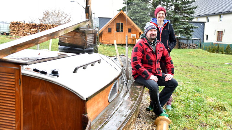 Levihus-Camping in Kleinwolmsdorf bei Arnsdorf: Die Inhaber Vincent Ackermann und Helena Erlbeck am Schlafboot mit Blick auf die Holzhütte, die gemietet werden kann.
