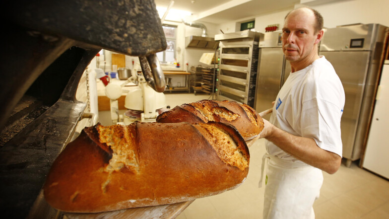 Lutz Chichowitz ist einer von drei Bäckern der Klosterbäckerei, die von der Behindertenwerkstatt St. Michael betrieben wird. Hier holt er gerade heißes Brot aus dem fast 95 Jahre alten Backofen der Marke Schmidt & Söhne. Er sorgt für die unverwechselbare
