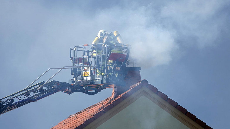 Schornsteinbrand in Grumbach. Feuerwehrleute bekämpfen den Brand von der Drehleiter aus.