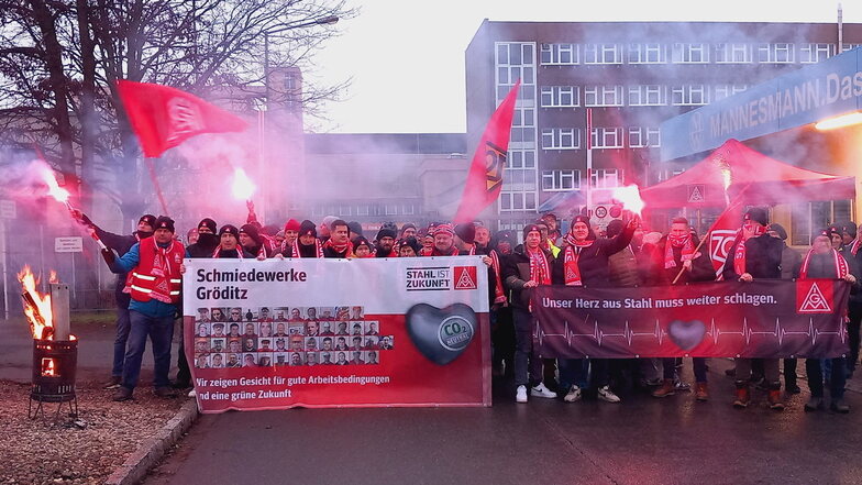 Mit Bengalfeuer und Gewerkschaftsflaggen streiken Stahlarbeiter vor den Toren der Mannesmannröhren-Werk GmbH in Zeithain.