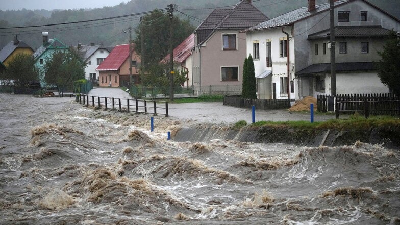 Tschechien, Mikulovice (Nickelsdorf): Der vom Hochwasser aufgewühlte Fluss Bela rauscht an Häusern vorbei. In Tschechien laufen die Schutzmaßnahmen vor Überschwemmungen auf Hochtouren.