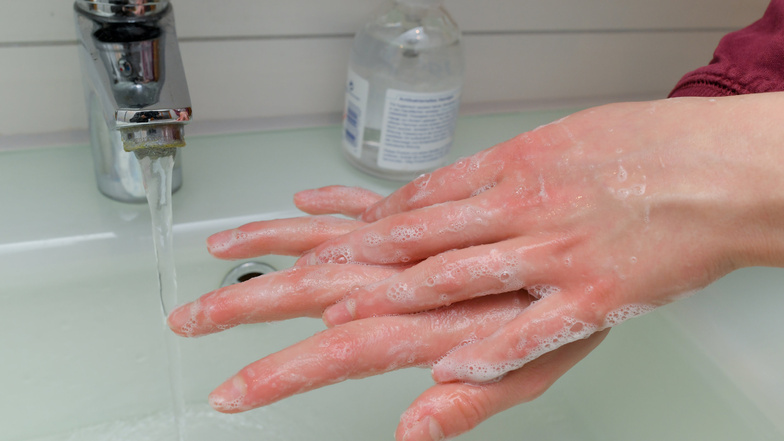Ein Mädchen wäscht sich die Hände mit Wasser und Seife.