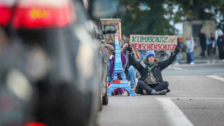 Acht Demonstranten blockieren am Freitagmorgen auf dem Straßburger Platz in Dresden eine der Straßen.