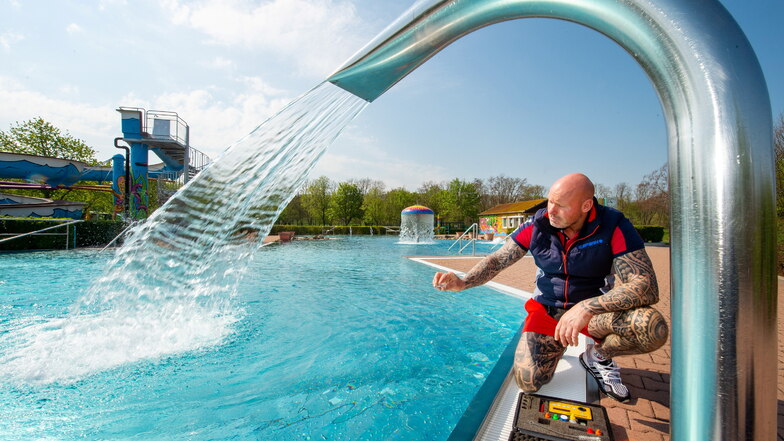 Der Leiter des Coswiger Freibades, Andreas Seelig, nimmt im Spaßbecken eine Wasserprobe. Die Anlage mit mehreren Becken und dem Naturbadesee ist seit dem Wochenende wieder geöffnet.