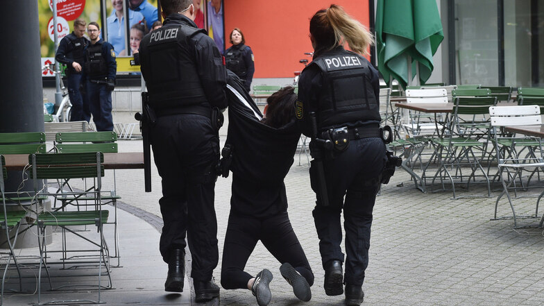 Eine Aktivistin wird nach der Besetzung des Parteigebäudes der CDU in Chemnitz von Polizisten weggetragen.
