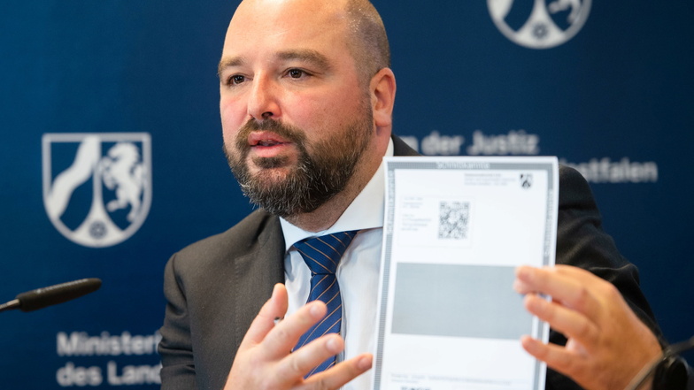 Andreas Brück, Staatsanwalt bei der Zentral- und Ansprechstelle Cybercrime (ZAC NRW), zeigt während einer Pressekonferenz ein Paper Wallet für Bitcoin.