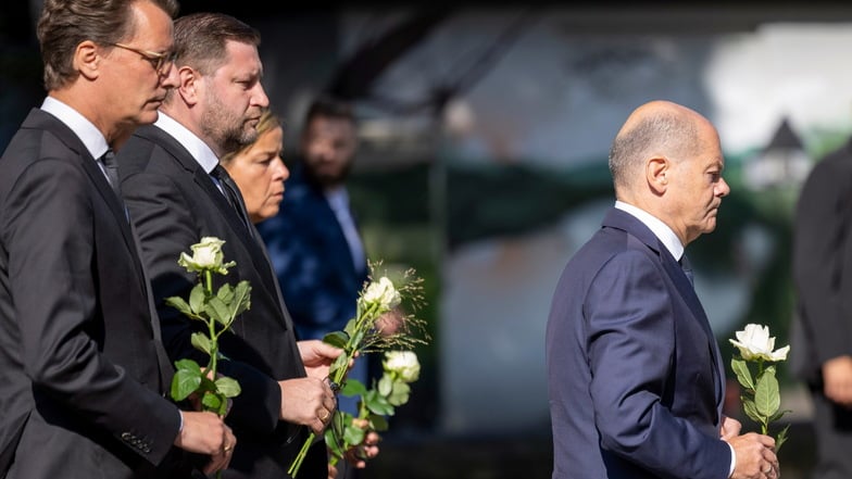 NRW-Ministerpräsident Hendrik Wüst (l-r, CDU), Tim Kurzbach (SPD), Bürgermeister von Solingen, Mona Neubaur (Grüne) und Bundeskanzler Olaf Scholz (SPD) legen weiße Rosen an einer Kirche in der Nähe des Tatorts ab.