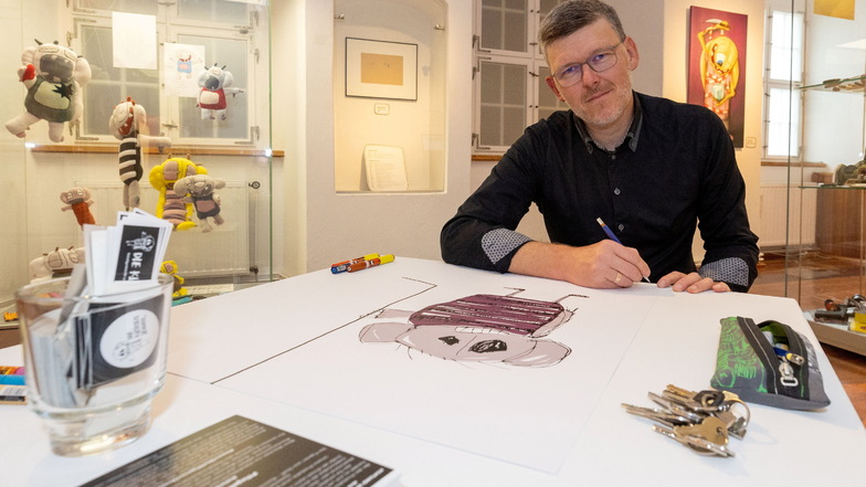 Sebastian Bieler beim Signieren von Plakaten zu seiner Ausstellung im Museum Alte Lateinschule Großenhain.