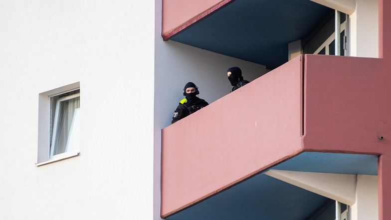 Polizeibeamte stehen bei der Razzia in Berlin auf einem Balkon.