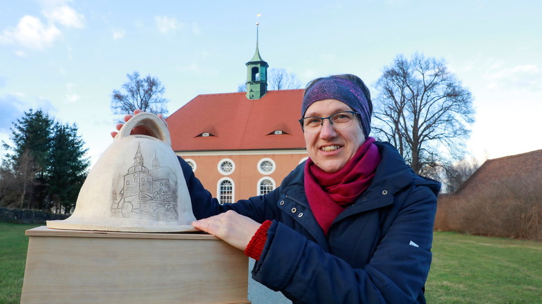 Pfarrerin Karin Baudach mit einer der beiden besonderen Spendenboxen für die Kirchenglocken.