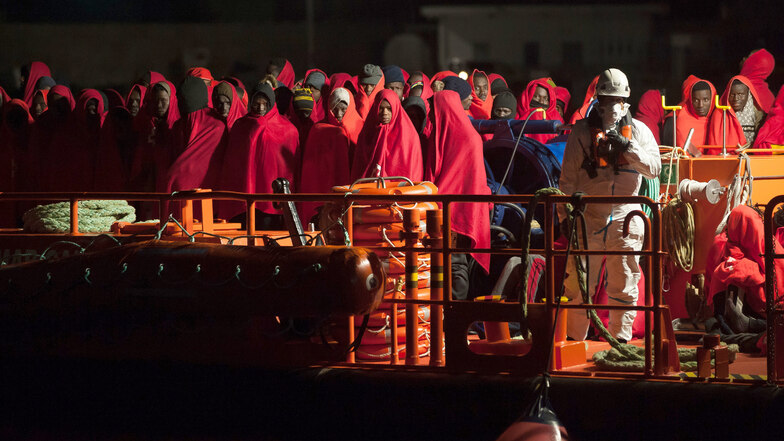 Eine Gruppe von Migranten, die von den spanischen Seebehörden gerettet wurden, steht auf einem Rettungsschiff, als sie im Hafen von Malaga ankommen.