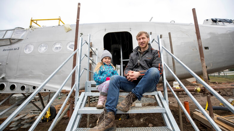 Erik Herbert mit seiner Tochter Klara sitzen auf der Treppe zum Eingang der Antonov.