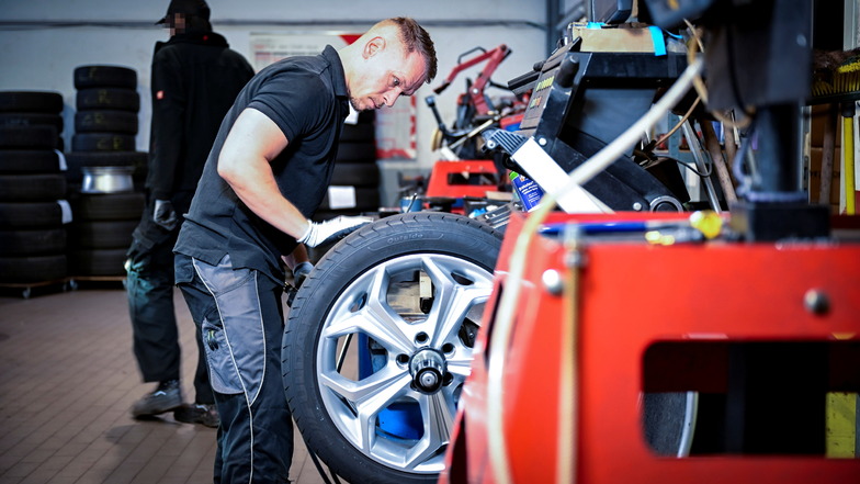 Reifenmonteur Marco Freiesleben hat ein Leichtmetallrad in die Wuchtmaschine gespannt. Unwuchten eliminiert der 35-Jährige durch Klebegewichte, die er im Felgeninneren fixiert.