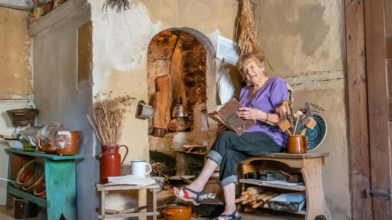 So hat man vor 300 Jahren gekocht. Regina Bonk sitzt vor einem Kamin in der Küche, der sich erhalten hat.