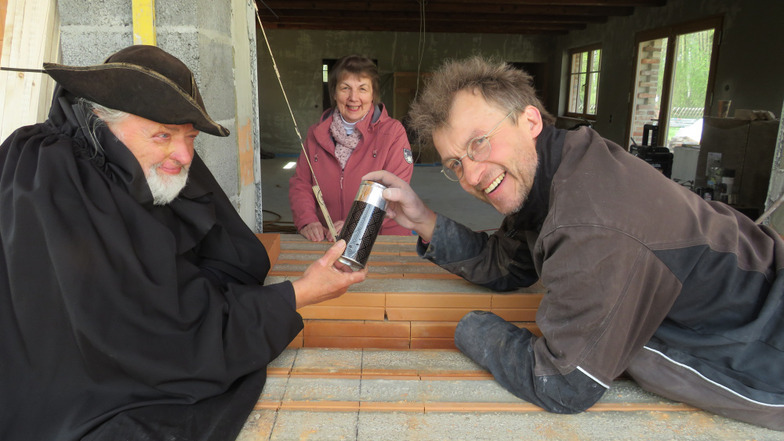 Im Bild zu sehen sind Dieter Klimek, Ofenbauer Olaf Giertz und die Mitarbeiterin der Krabat-Mühle Karin Trautmann kurz vor dem Versenken der Zeitkapsel.