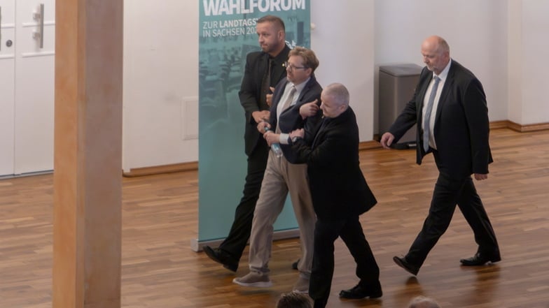 Bevor das Wahlforum im Riesaer "Stern" beginnen konnte, mussten Sicherheitsleute den Kandidaten der Freien Sachsen, Peter Schreiber, nach draußen geleiten.