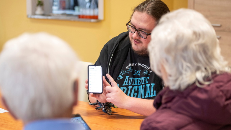 Medienpädagoge Florian am Ende erklärt in der Großenhainer Senioren-Begegnungsstätte Alleegässchen älteren Interessenten den Umgang mit dem Smartphone.